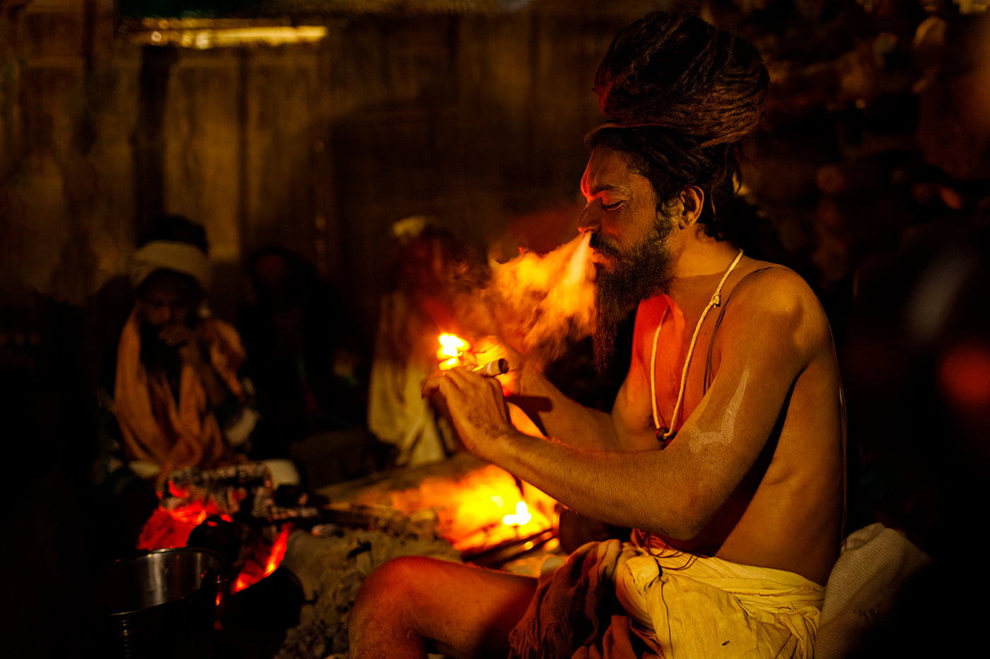 A Naga Sadhu smokes a chillum at the Kumbh Mela in Allahabad, India.