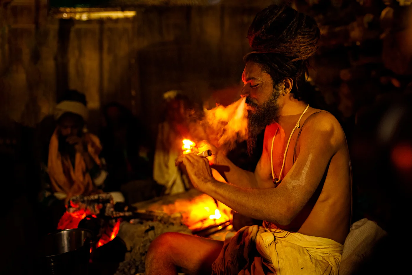 A Naga Sadhu smokes a chillum at the Kumbh Mela in Allahabad, India.