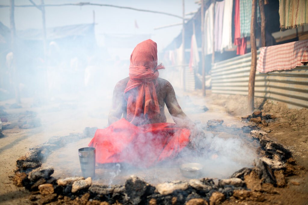 A Vaishnava Sadhu, who is a devotee of Lord Vishnu, is performing Dhuna Tapasya Panch Agni Tapasya.