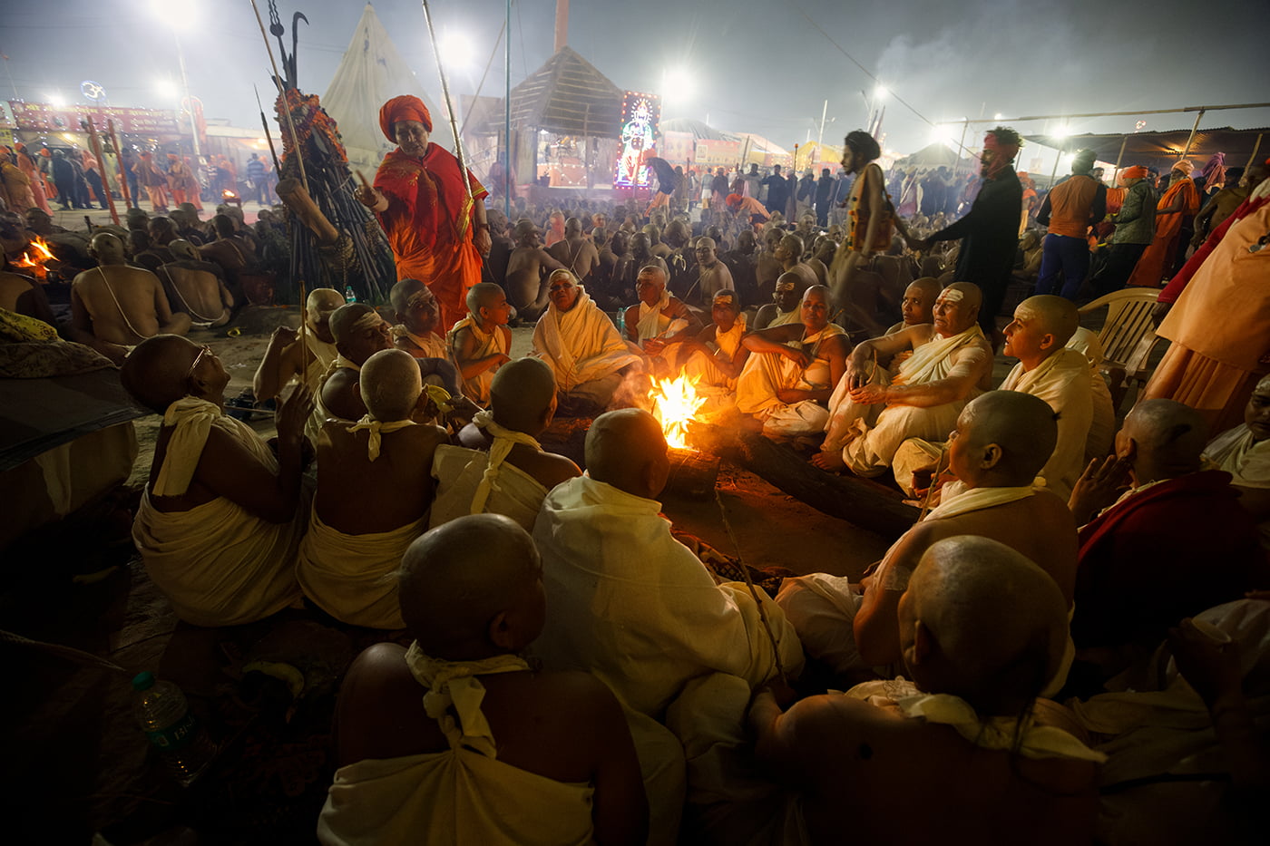 A group of Naga Sadhvis also called “Maata” are sitting in front of a fire during a mass initiation ceremony.
