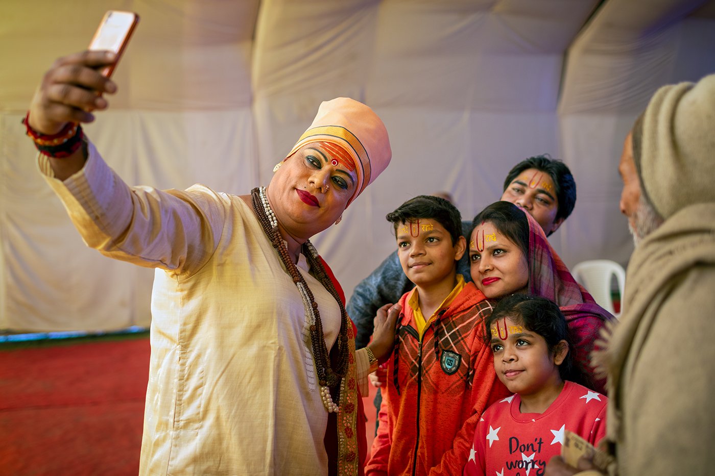 Pavitra Nimbhorakar, a leader and secretary of the Kinnar Akhada, with a devotee family at the 2019 Kumbh Mela.