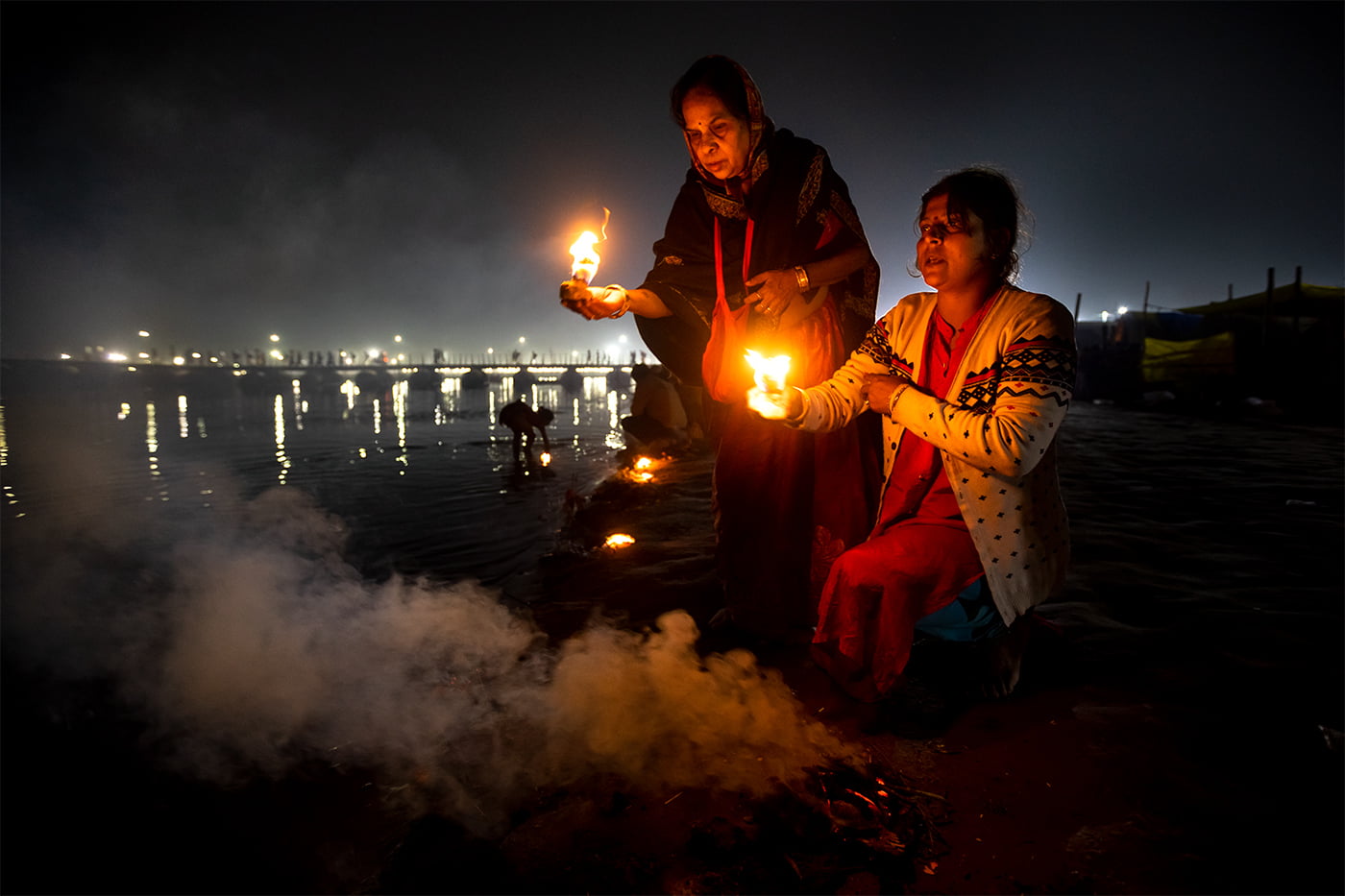 A mother and her daughter are performing Sondhi Puja (Evening Puja) on the Ganges in the 2019 Kumbh Mela.